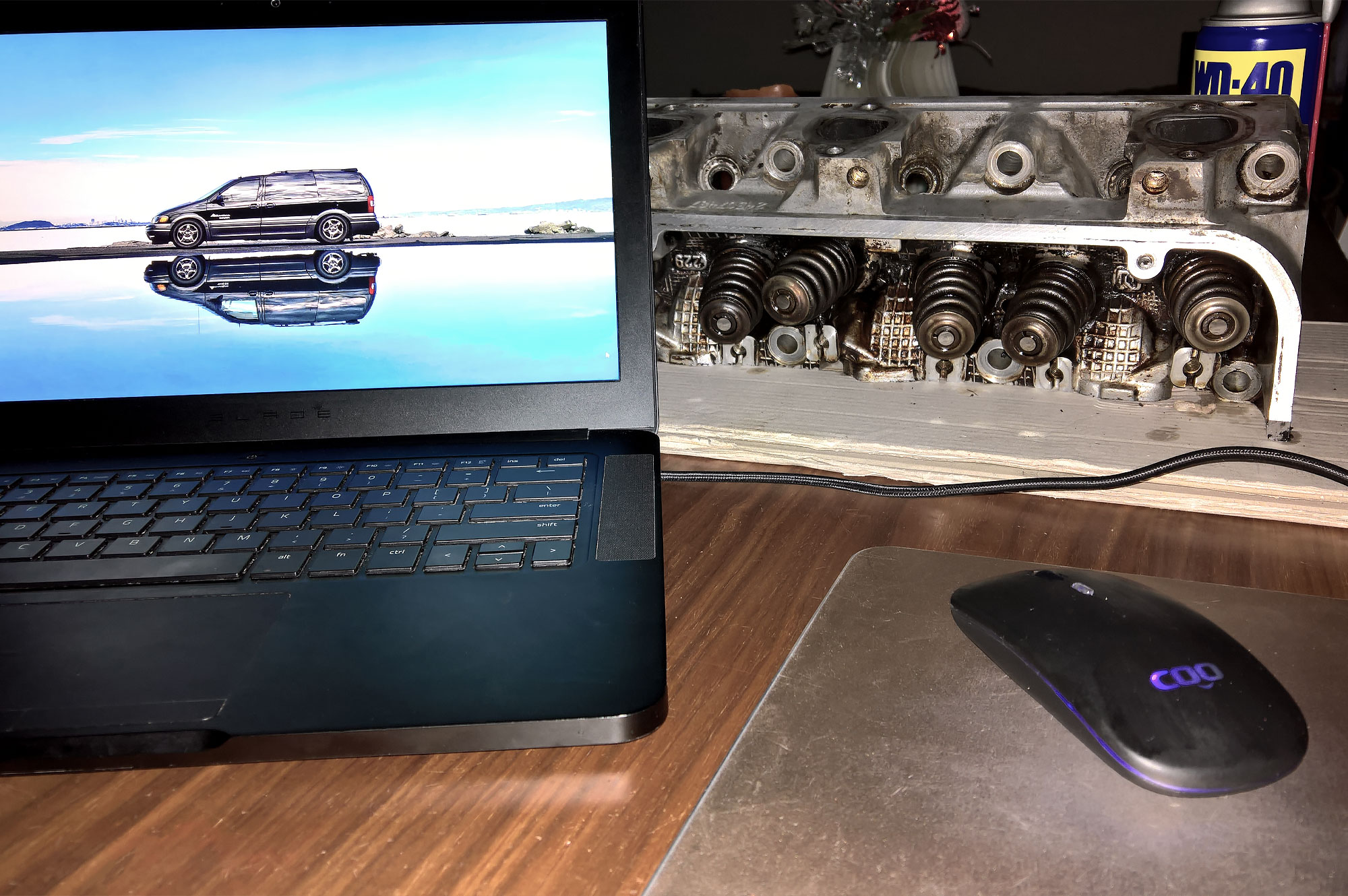 A photo of 2003 AWD Pontiac Montana Thunder shown on a screen of a 2016 Razer Blade laptop; next to the computer is one of the heads from the van.